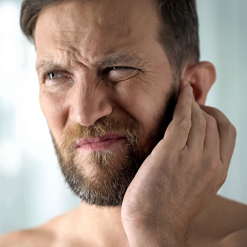 Man holding ear