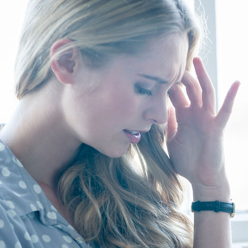 Woman holding her head because she is dizzy.